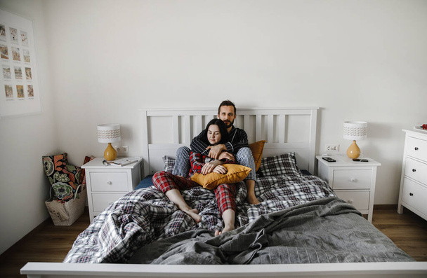 happy family cuddling at home in a stylish interior on the bed - Foto, Bild
