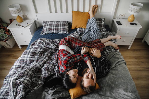 happy family cuddling at home in a stylish interior on the bed - Valokuva, kuva