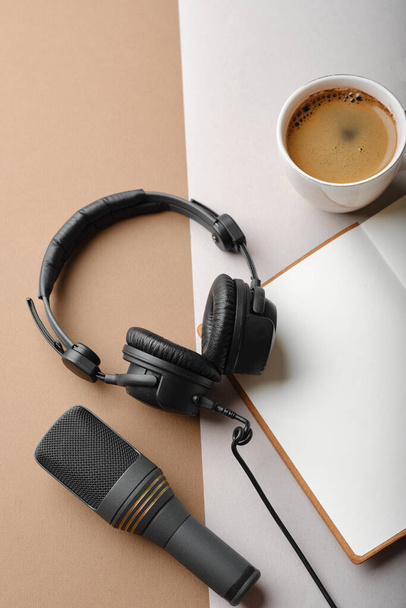 Flat lay composition with Microphone for podcasts  and black studio headphones on brown background with coffee and laptop, learning online education concept - Фото, изображение