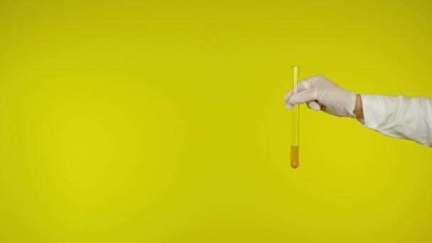 Ruka v latexové rukavici ochrana ukazuje skleněnou trubici s látkou - Záběry, video