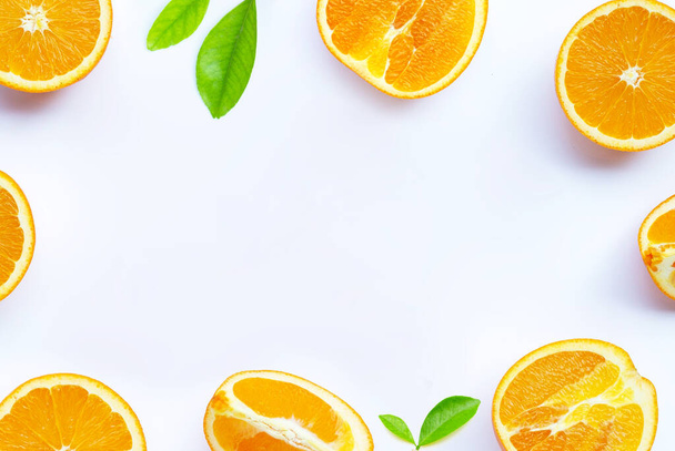 Vitamina C alta, jugosa y dulce. Marco de fruta fresca de color naranja con hojas sobre fondo blanco. Copiar espacio
 - Foto, imagen
