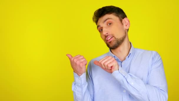 Hombre barbudo guapo muestra sus dedos en un lugar vacío para texto o producto
 - Metraje, vídeo