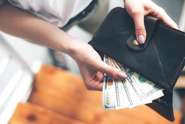 Wallet with dollar bills in female hands. Budget. Financial crisis. - Φωτογραφία, εικόνα