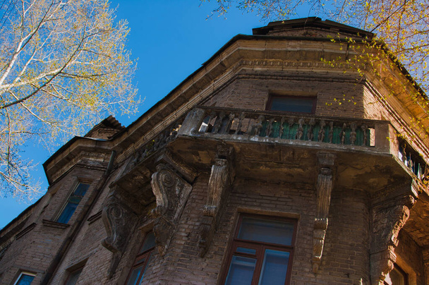 Les murs de la vieille maison sont décorés avec des balcons massifs, des éléments décoratifs, des colonnes et des bas-reliefs
 - Photo, image