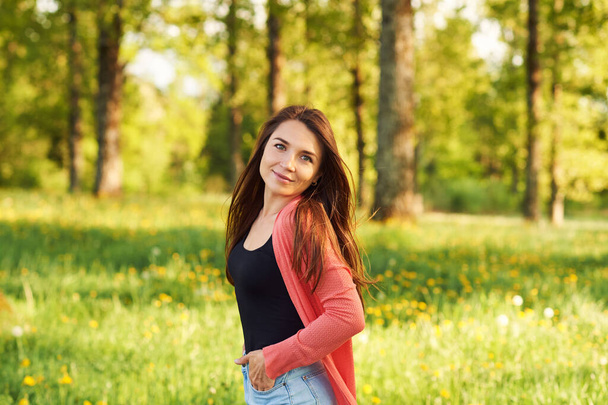 Retrato ao ar livre de bela jovem com cabelo castanho, relaxante na natureza
 - Foto, Imagem