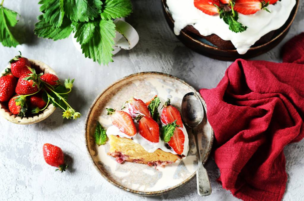 Cake with cream and strawberries on a plate on a black background - Photo, Image