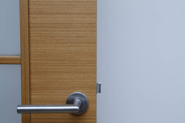 Зовнішня дверна ручка та замок безпеки на металевій рамі
 - Фото, зображення