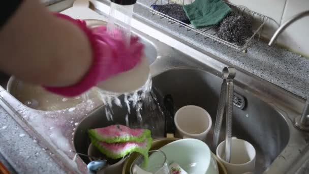 Le mani di una persona che lava i piatti dopo un pasto nella cucina di casa
. - Filmati, video