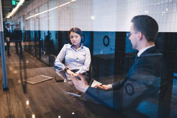 Grâce au verre vue de femme asiatique confiante candidate au chômage en chemise formelle réunion avec le gestionnaire masculin pour une entrevue au bureau - Photo, image