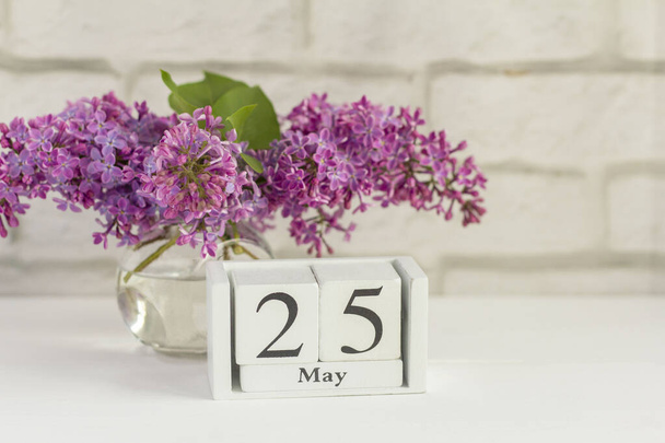 ライラックの花束の横にある木製のカレンダーに5月25日。春の一日。学校の終わり。. - 写真・画像