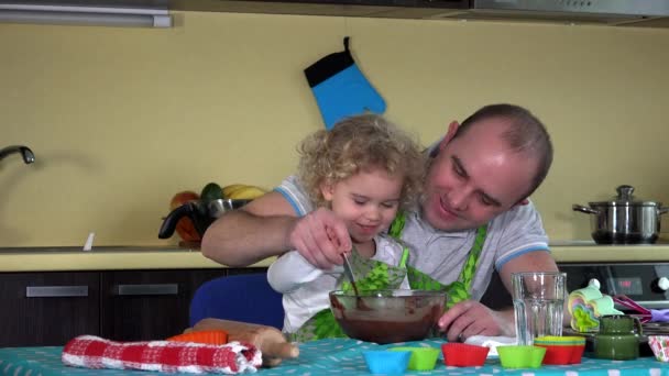 Vater und Tochter mischen in der Küche Schokoteig für Kuchen. 4K - Filmmaterial, Video