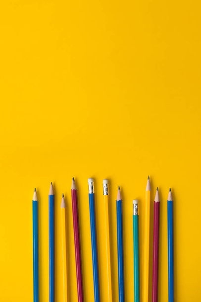 Színes ceruzák halmaza sárga papíron fénymásoló felülettel, oktatási háttér koncepció - Fotó, kép