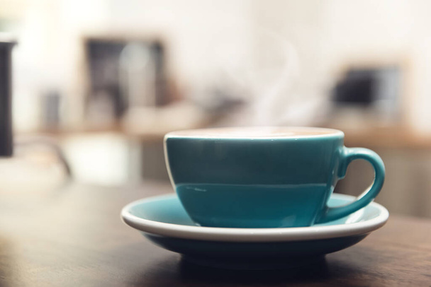 Ζεστός φρέσκος καφές σε μπλε τυρκουάζ κύπελλο στο τραπέζι του ξύλου έτοιμος να πιει - Φωτογραφία, εικόνα