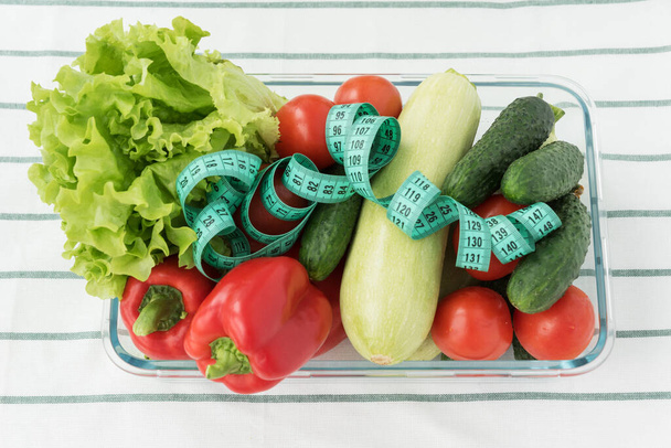 野菜と大きな透明プレートのトップビュー:サラダ,トマト,ピーマン,ズッキーニ,キュウリ.ダイエットの概念。体重やカロリーのコントロールや健康的な食事やライフスタイルを.  - 写真・画像
