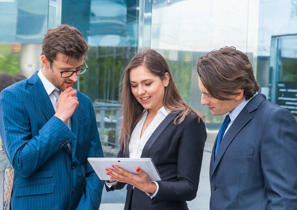Teamwork and business concept. Confident businesspersons in formal wear having conversation about banking and financial markets in front of office building. Businessmen and businesswoman. - Foto, imagen