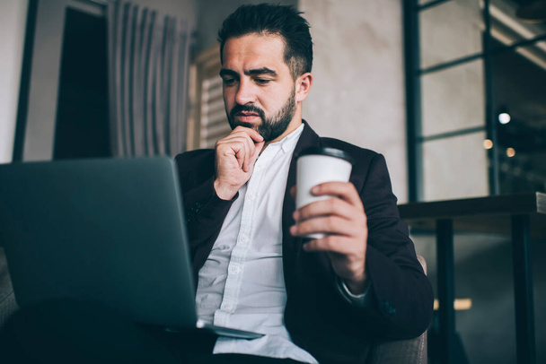 Thoughtful caucasian businessman trader pondering on news from exchange using laptop computer, pensive male executive converted on finance report read report online via modern devices on freelance - Фото, зображення