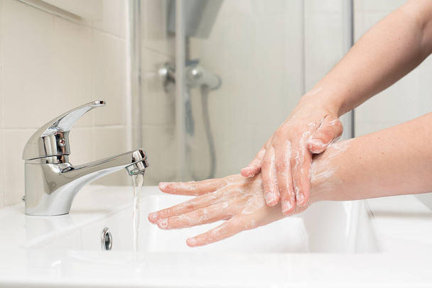 Woman washing hands at home - 写真・画像