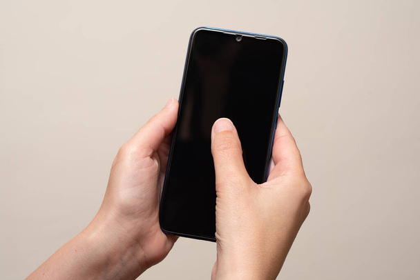 mano femenina sosteniendo el teléfono móvil en el interior
 - Foto, imagen
