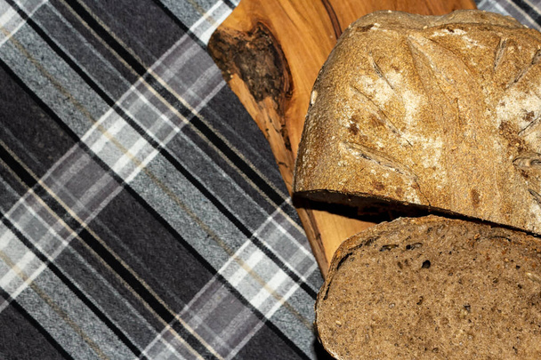 чорний зерновий хліб, розташований на обробній дошці
. - Фото, зображення