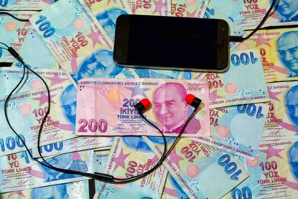 Turkish banknotes composition of technological expenditures with mobile phone and headset - Valokuva, kuva