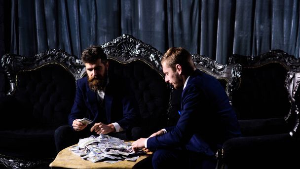 Criminals count dollars. Bearded man and his friend with money. - Valokuva, kuva