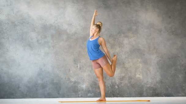 jóga edző csinál nyújtás gyakorlatok szőnyeg padláson stúdió lassított felvétel - Felvétel, videó