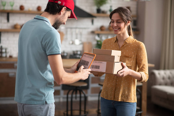 Female customer receiving boxes from a delivery person - Φωτογραφία, εικόνα