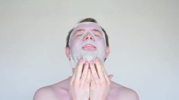 Fehér férfi eltakarja arcát egy kozmetikai maszkkal.. - Felvétel, videó