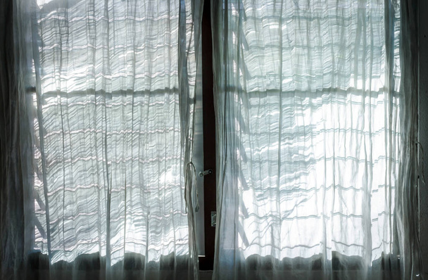 Fény a napból és árnyékok ablaktáblával és fehér függönnyel - Fotó, kép