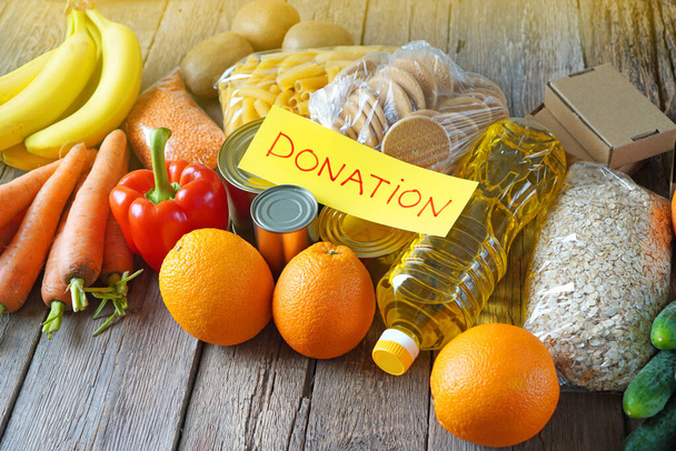 Fundo de doação de alimentos com vários produtos: macarrão, aveia, legumes, frutas, óleos, cozinhas e texto Doação
 - Foto, Imagem