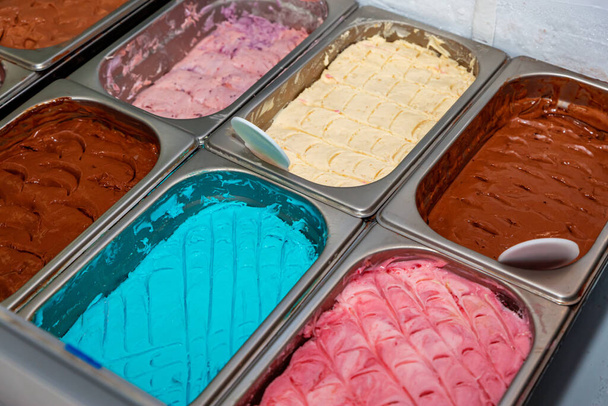Farklı aromalı dondurma tezgahında bir sürü kepçe aromalı dondurma. Tezgahta çeşitli Icecream tatları var. - Fotoğraf, Görsel