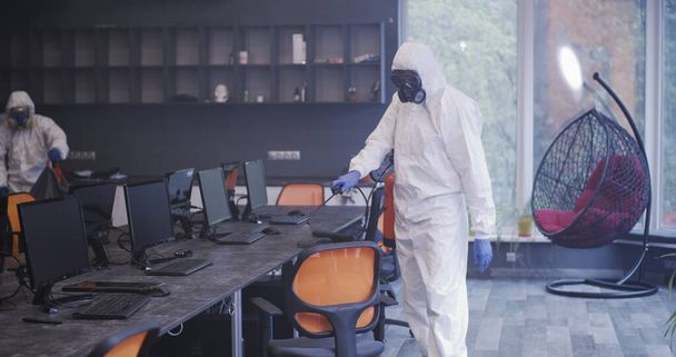 Muži v ochranných oblecích dezinfikují kancelář - Fotografie, Obrázek