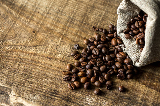 Coffee beans on a wooden old texture background. Organic coffee - Foto, afbeelding
