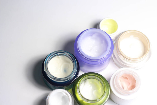 Mistura de natas de cara da bela pele nos jarros coloridos vívidos
 - Foto, Imagem