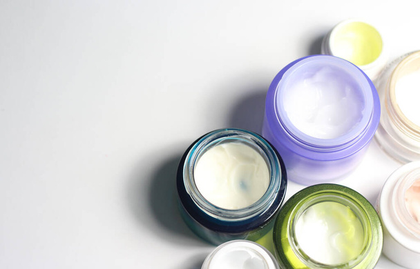 Mélange de crèmes pour le visage pour une belle peau dans les pots colorés vifs
 - Photo, image