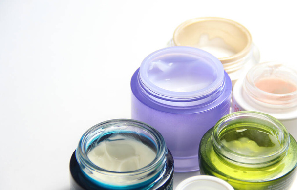 Meng van gezichtscrèmes voor een mooie huid in de levendige kleurrijke pot - Foto, afbeelding