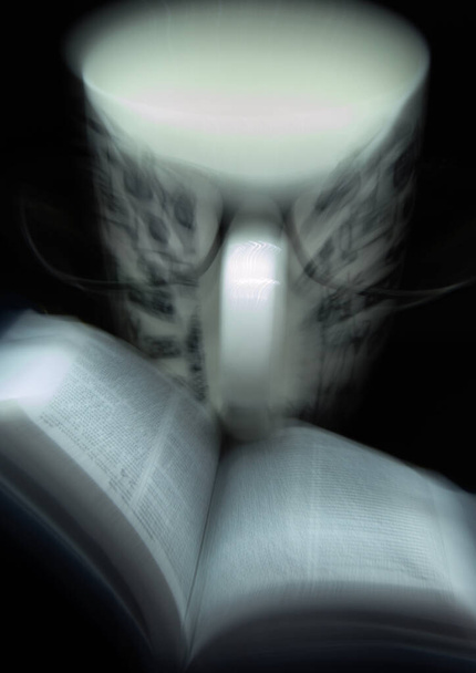Taza con lente, libro y efecto de movimiento
 - Foto, Imagen