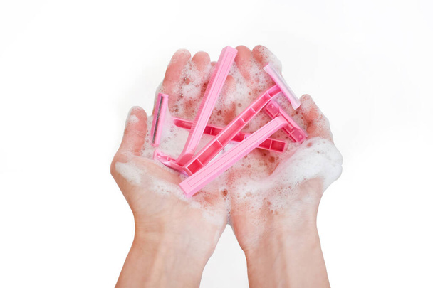 Chica sosteniendo un montón de afeitadora rosa en la mano
 - Foto, imagen