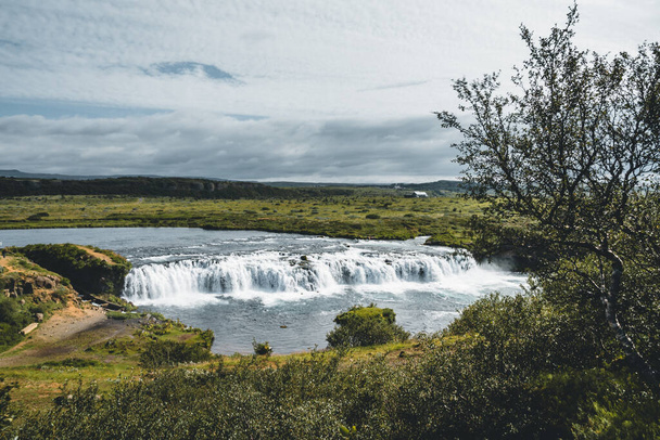 Faxafoss Faxi waterfall landscape shot with trail path in south Iceland. Water falling flowing on Golden Circle during midnight sun. Wide angle scene. - 写真・画像