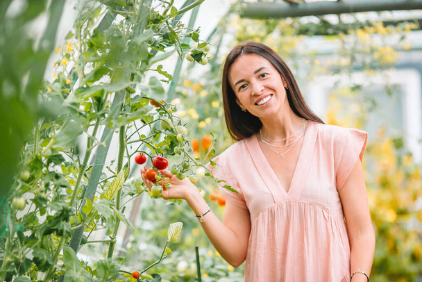 Красивая молодая женщина садоводство в оранжерее
 - Фото, изображение
