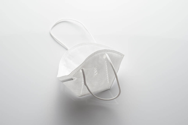 White face mask on white background. Protector to prevent contagion. - Фото, изображение