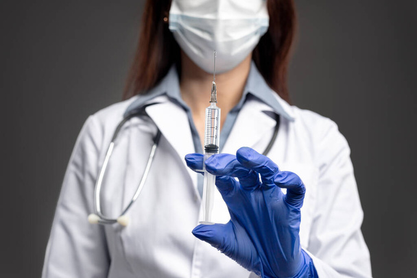 Crop nurse showing syringe of vaccine - Photo, image