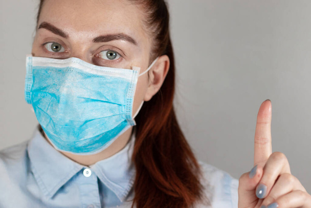 Dziewczyna w masce medycznej na szarym tle. Ochrona przed chorobami, epidemiami i wirusami. Koronawirus, kowid 19 - Zdjęcie, obraz