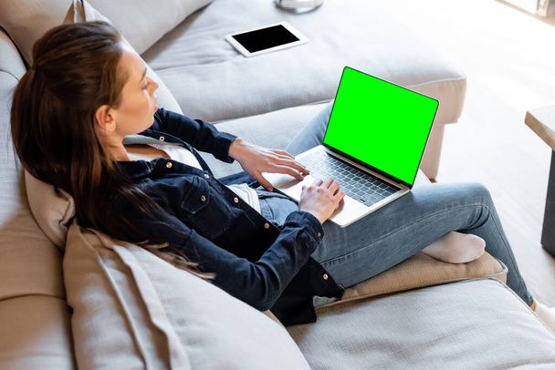 selektive Fokussierung des Freelancer mittels Laptop mit grünem Bildschirm in der Nähe von digitalem Tablet mit leerem Bildschirm  - Foto, Bild