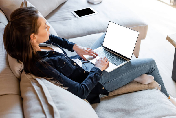 foco seletivo do freelancer usando laptop com tela branca perto de tablet digital com tela em branco
  - Foto, Imagem