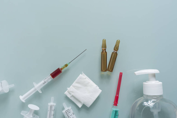 several syringes, dressings, disinfectant and two medication containers on a green background - Photo, Image