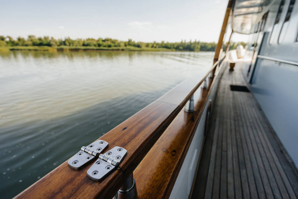 Holzgeländer auf einem teureren Flussboot vor dem Hintergrund von Wasser und Himmel. - Foto, Bild