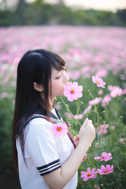 Retrato de japonês escola menina uniforme com rosa cosmos flor  - Foto, Imagem