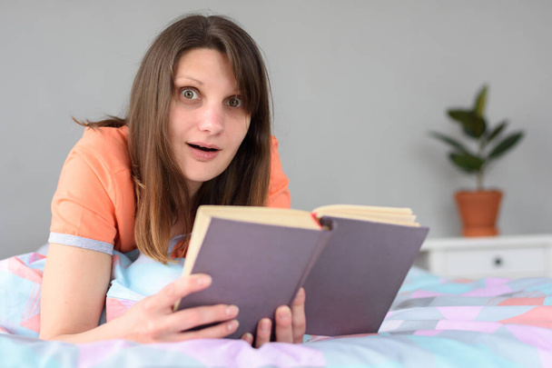 Das Mädchen in einem leichten Schock von der Lektüre in einem Buch - Foto, Bild