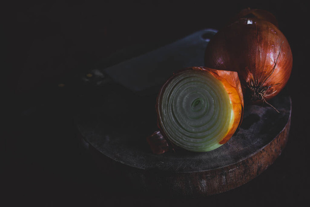 料理、きれいな生活と健康的な食事の概念を表示するには、低光暗いと気分のテーマで撮影されたタマネギの球根 - 写真・画像